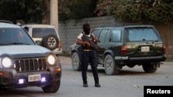 FILE - A police officer patrols a street in Port-au-Prince, Haiti, Dec. 11, 2024. Security units worked Feb. 8, 2025, to disrupt activities organized by the 400 Mawozo gang. 