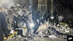 En esta imagen proporcionada por la oficina de prensa de la policía ucraniana, trabajadores de emergencia trabajan en el lugar de un edificio destruido de varias plantas tras un ataque ruso contra un vecindario residencial en Odesa, Ucrania, el sábado 2 de marzo de 2024