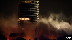 Asap mengepul dari lokasi di mana sisa menara Champlain South dihancurkan di Surfside, Florida, utara Miami Beach, pada 4 Juli 2021. (Foto: AFP)