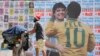 Un hombre empuja un carrito lleno de basura para reciclar frente a un mural en el que se muestra al astro brasileño Pelé abrazando a la difunta estrella del fútbol, el argentino Diego Maradona, en Sao Paulo, Brasil, el 24 de diciembre de 2022. 