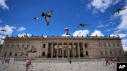 ARCHIVO - Peatones caminan por la Plaza Bolívar frente al Capitolio Nacional, en Bogotá, Colombia, el 22 de septiembre de 2021.