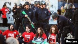 Polisi bersiap menahan demonstran yang menyerukan upah minimum US$15 per jam dalam demonstrasi di Los Angeles, California (29/11). (Reuters/Lucy Nicholson)