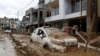 A car parked outside a building is swamped in mud, in Kathmandu, Nepal, Sept. 30, 2024, in the aftermath of flooding caused by heavy rains. 