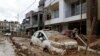 Sebuah mobil yang terparkir di luar sebuah gedung di Kathmandu, Nepal, tampak diselimuti lumpur pada 30 September 2024, menyusul banjir yang menerjang wilayah tersebut. (Foto: AP/Gopen Rai)