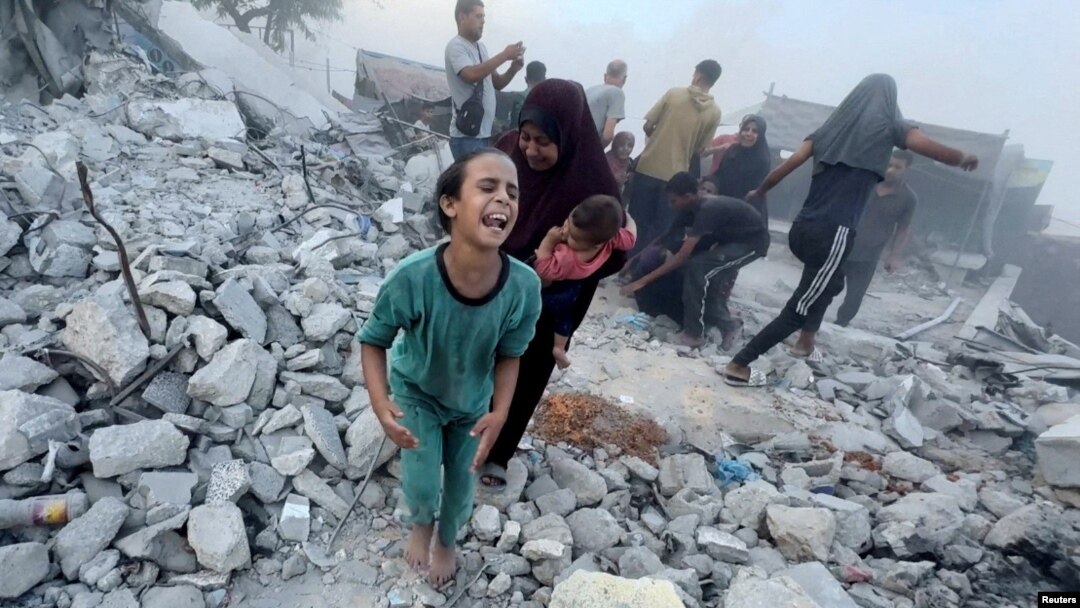 Palestinians react following an Israeli strike near a U.N.-run school sheltering displaced people in Khan Younis, Gaza Strip, in this still image taken from a video, July 3, 2024.