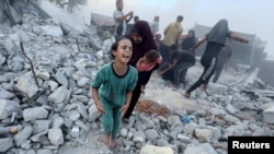 Palestinians react, following an Israeli strike near a UN-run school sheltering displaced people, amid the Israel-Hamas conflict, in Khan Younis, southern Gaza Strip, in this still image taken from a video, July 3, 2024.