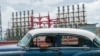 A person drives a classic American car past a floating generator that has not been producing electricity for days in Havana, Cuba, Oct. 18, 2024. 