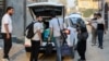 People unload luggage upon arriving at a house sheltering families of Lebanese refugees who were evacuated from Beirut's southern suburbs due to Israeli bombardment, in the city of Hilla in Iraq's central Babylon province, Oct. 9, 2024. 