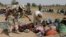 FILE- Soldiers guard people fleeing from Boko Haram’s carnage, Dec. 8, 2015. People detained by the military and a civilian self-defense force are disappearing in northeast Nigeria some wrongly accused of fighting for Boko Haram.