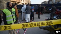 Pihak berwajib Pakistan memeriksa barang bukti di lokasi ledam bom di Ganj Mandi bazar dekat pos polisi di kota Rawalpindi, Pakistan, Minggu (13/12).