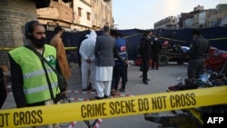 Security officials inspect the site of an explosion at a Ganj Mandi bazar in Rawalpindi on Dec. 13, 2020. 