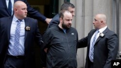 Marc Lamparello, 37, center, is escorted out of a police precinct in New York, April 18, 2019. 