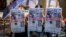 People hold up copies of the Apple Daily as they protest for press freedom 