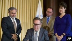 Deputy Secretary of Energy Dan Brouillette, left, Acting White House Chief of Staff Mick Mulvaney, and Chairman of the Council on Environmental Quality (CEQ) Mary B. Neumayr, stand as EPA administrator Andrew Wheeler signs the Affordable Clean Energy Rule