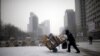 FILE - A man carries scraps in a handcart during snowfall in central Seoul, South Korea, Feb. 16, 2016. With the recycling market dimming, Seoul is turning to upcycling to reduce waste.