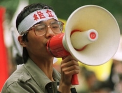Chinese dissident Wang Dan addresses fellow students during a demonstration in Beijing's Tiananmen Square, in this May 1989 photo. The characters on Wang's headband translate as "hunger strike."