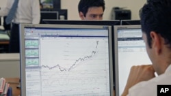 Traders at the Saxo Banque study their screens in their offices in Paris, August 10, 2011