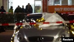 Un auto dañado y agentes de policía cerca del lugar de un tiroteo en Hanau, Alemania. Febrero 20, 2020. Foto: Reuters.