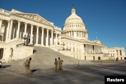 National Guard troops cross the grounds of the U.S. Capitol building on Capitol Hill in Washington, Jan. 10, 2021.