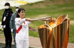 The last Olympic torch relay runner for the Osaka leg concludes the event in Suita, north of Osaka, western Japan, April 14, 2021.