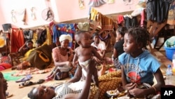 A woman plays with her baby inside a Roman Catholic Church in Pemba city on the northeastern coast of Mozambique in this Monday, April, 29, 2019 photo.