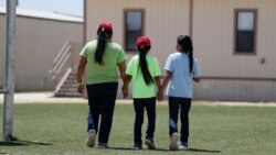 Immigrants seeking asylum hold hands as they leave a cafeteria at the ICE South Texas Family Residential Center, Aug. 23, 2019, in Dilley, Texas.