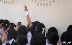 Pro-democracy students raise a three-finger salute, a symbol of resistance, during a protest rally in front of Education Ministry in Bangkok, Thailand, Wednesday, Aug. 19, 2020.