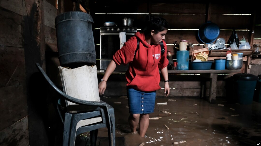 A woman walks into her house, flooded during the passage of Hurricane Iota in Siuna, Nicaragua, Nov. 17, 2020.