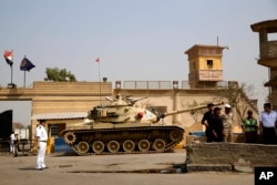 FILE - In this Aug. 2, 2015 photo, Egyptian security forces stand guard outside one of the entrances of Tora prison, in Cairo. Human Rights Watch alleges systematic torture inside police stations and Interior Ministry headquarters where officers act in “almost total impunity.”