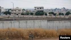 Turkish soldiers patrol along a wall on the border line between Turkey and Syria, in the Turkish border town of Ceylanpinar, in Sanliurfa province, Turkey, Oct. 29, 2019.