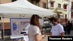 Volunteers show residents how to install an app to trace contacts with people potentially infected with the coronavirus disease (COVID-19) being trialled on the Canary Island of La Gomera