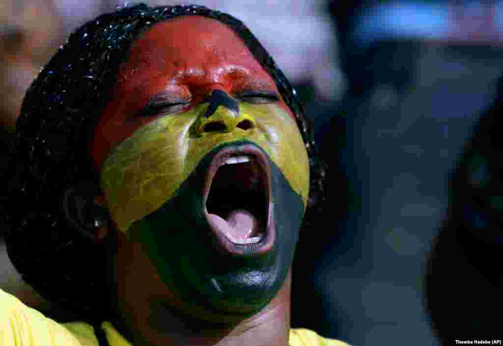 Seorang penggemar sepakbola dari Ghana dengan wajah dicat berteriak menyemangati tim negaranya dalam pertandingan Grup C Piala Afrika di Mongomo, Guinea Ekuatorial (19/1). (AP/Themba Hadebe)