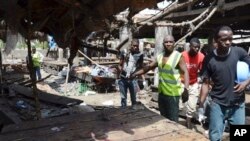 Rescue workers at the site of a suicide bomb attack at a market in Maiduguri , Nigeria, Tuesday, June 2, 2015. Boko Haram attacked the northeastern Nigerian city of Maiduguri with deafening explosions from the west and a suicide bombing near the center that witnesses said killed as many as 20 people. (AP Photo/Jossy Ola)