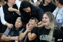 FILE - The mother (C) of Naor Hassisim, a victim of the Kibbutz Kfar Aza attack last week by members of the Palestinian militant group Hamas, is comforted during his funeral at a cemetery, in southern Israeli city of Ashdod on October 16, 2023.