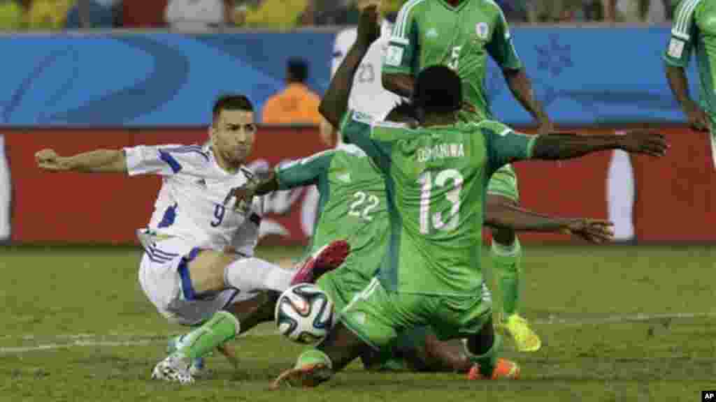 Nigeria's Juwon Oshaniwa, right No 13, blocks a shot by Bosnia's Vedad Ibisevic.