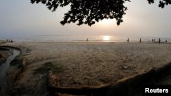 FILE - Visitors walk along a beach in Libreville, Gabon, Feb. 2, 2017. 