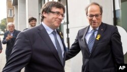 El ex líder catalán, Carles Puigdemont, izquierda, es recibido por el actual presidente regional catalán, Quim Torra, quien viajó a Bélgica. 