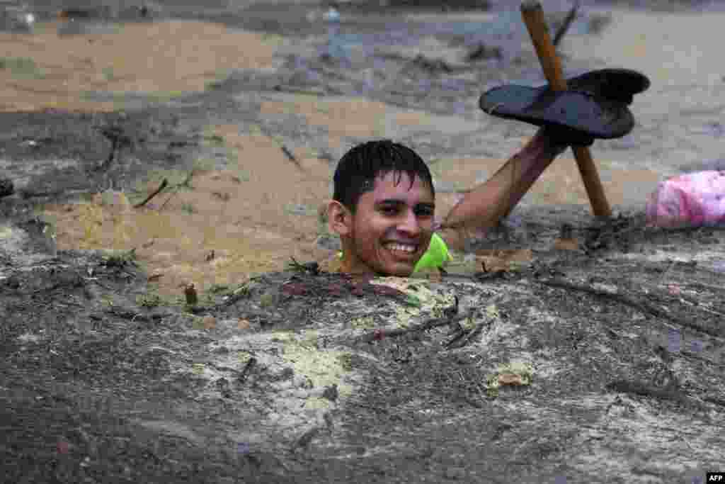 A man wades through flood waters in the Alemania suburb, which was flooded by the La Arenera stream after heavy rains caused by Storm Eta, in El Progreso, 260 kilometers north of Tegucigalpa, Honduras, Nov. 4, 2020.