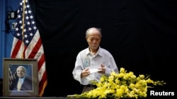 Vietnamese veteran Pham Minh Chuc, 81, pays respect after he wrote in a condolence book near a portrait of U.S. Senator John McCain (R-AZ) about his death at the U.S. embassy in Hanoi, Vietnam, Aug. 27, 2018. 