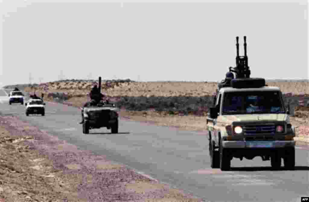 Anti-Libyan Leader Moammar Gadhafi rebel vehicles, drive back from the front line at a desert road between Agela and Ras Lanouf towns, eastern Libya, on Saturday March 12, 2011. An emergency European Union summit on Libya brought a no-fly zone no closer, 