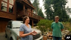 Diane Nelson and her husband, Rick, discuss the approaching Caldor Fire that threatens their home on Fallen Leaf Lake near South Lake Tahoe, Calif., Aug. 24, 2021.