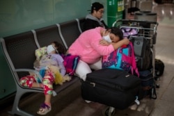 Passengers rest at the Barcelona airport, Spain, Thursday, March 12, 2020.