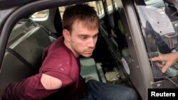Travis Reinking, the suspect in a Waffle House shooting in Nashville, is under arrest by Metro Nashville Police Department in a wooded area in Antioch, Tennessee, April 23, 2018. 