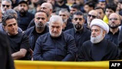 TOPSHOT - Naim Qassem (R), deputy secretary-general of the Lebanese Shiite movement Hezbollah, and Mohammed Raad (C), head of Hezbollah's bloc in the Lebanese parliament, attend the funeral of top Hezbollah military commander Ibrahim Aqil in Beirut's sout