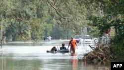 A resident tows an air mattress with people on it through flooded streets in Tampa due to Hurricane Milton on October 10, 2024 in Florida.