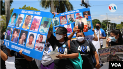 Familiares de víctimas de las protestas de 2018 muestran pancantas a policías. Foto Houston Castillo, VOA.