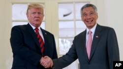 El presidente Donald Trump estrecha la mano del primer ministro de Sinagpur, Lee Hsien Loong, antes de la cumbre con Corea del Norte prevista para el martes.