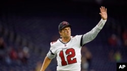 Quarterback Tampa Bay Buccaneers Tom Brady melambaikan tangannya ke arah para fans ketika ia meninggalkan lapangan setelah tampil dalam pertandingan melawan Houston Texans, di Houston, pada 28 Agustus 2021. (Foto: AP)