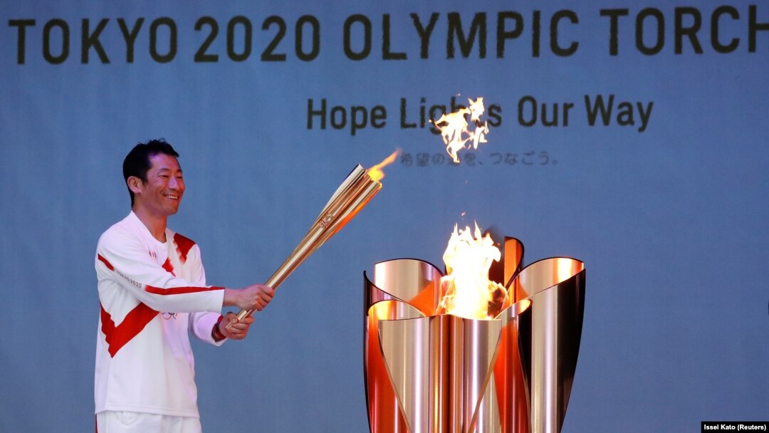Pembawa obor Olimpiade Yoshihide Muroya, pilot aerobatik Jepang dan pilot balap Red Bull Air Race World Championship, pada leg terakhir hari pertama estafet obor Olimpiade Tokyo 2020, di Minamisoma, prefektur Fukushima, Jepang, 25 Maret 2021. (Foto: REUTERS)