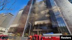 Asap kebakaran membubung dari gedung yang sedang dibangun di Busan, Korea Selatan, Jumat, 14 Februari 2025. (Foto: Yonhap via Reuters)